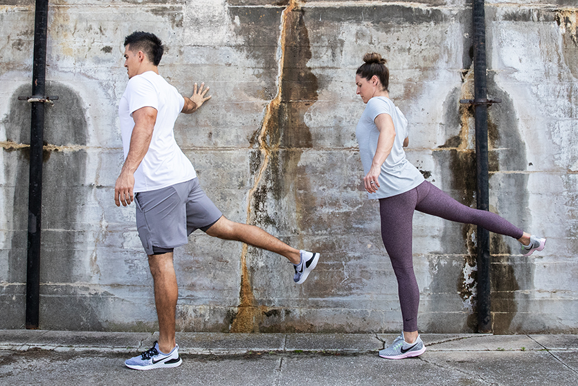 Male and female doing pre-run stretches.